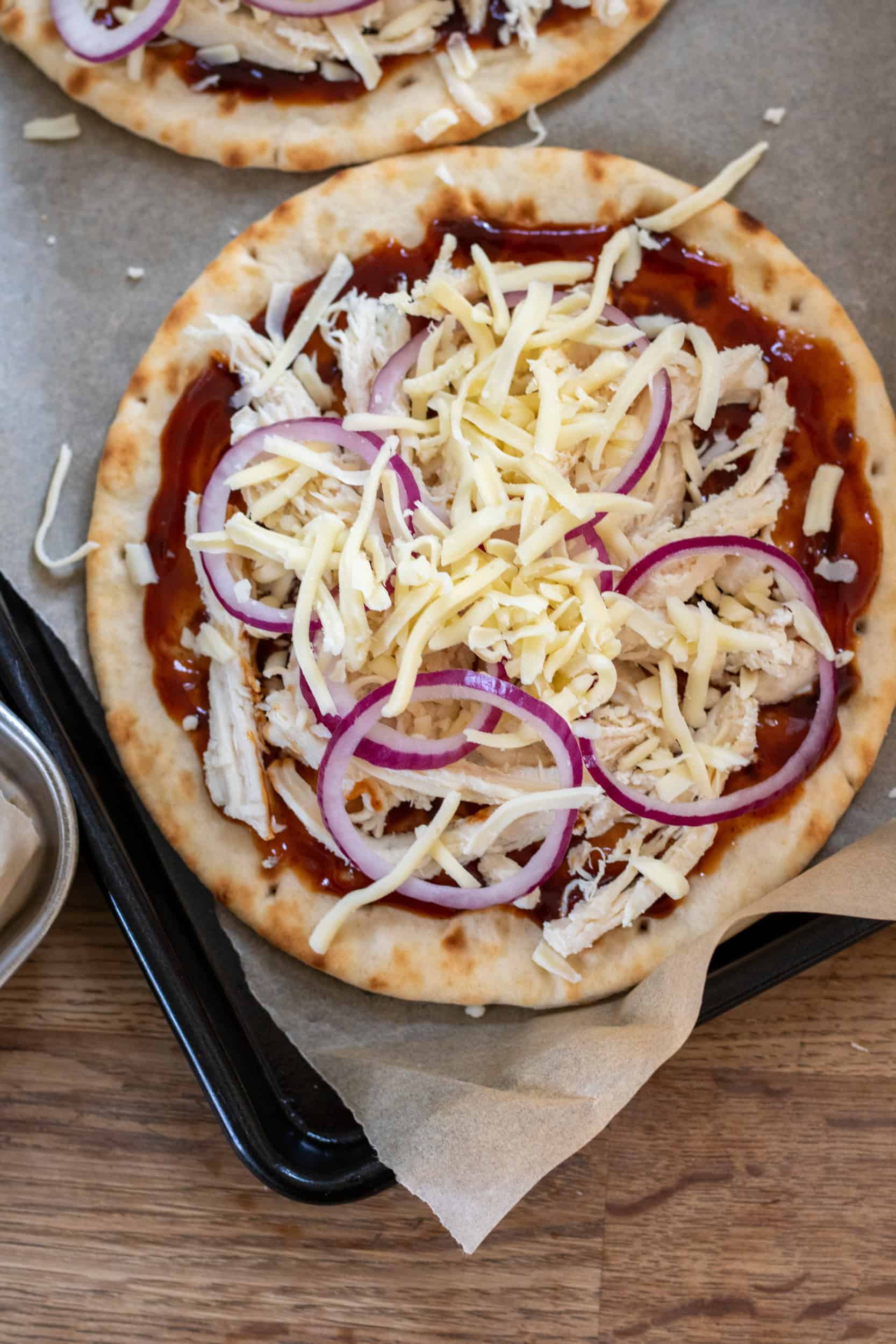 Adding cheese to the flatbreads.