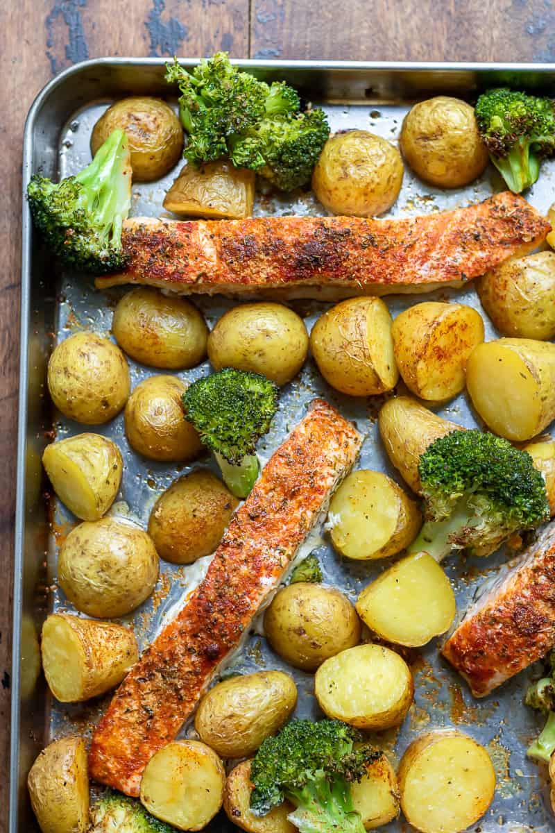 Looking down at a sheet pan with roasted salmon, potatoes and broccoli.