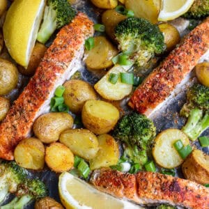 Sheet pan salmon, potatoes and broccoli, with wedges of lemon and scallions.