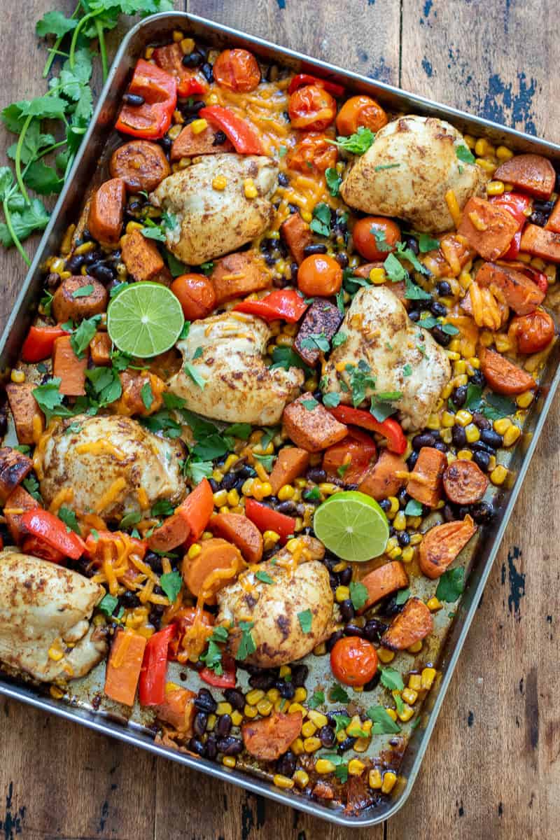 Looking down at a table with a pan of Chipotle Chicken Sweet Potato Sheet Pan Dinner.