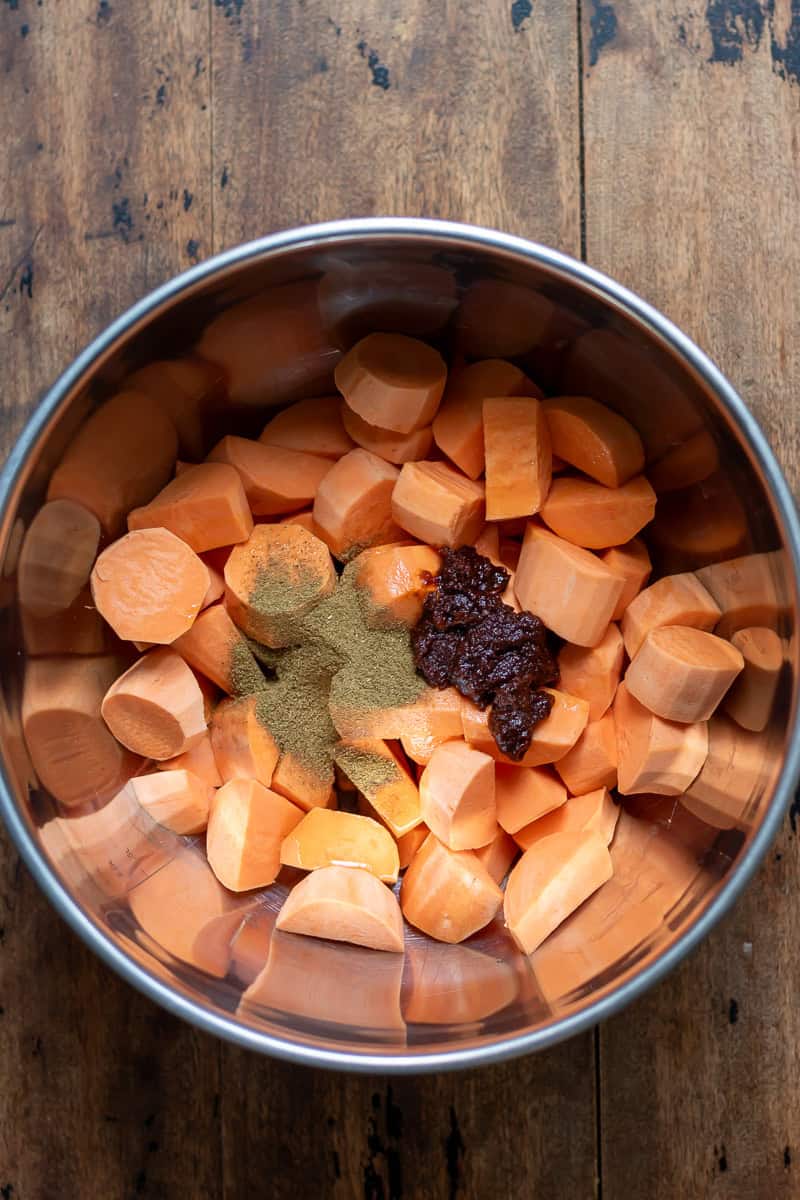 Cubed sweet potatoes in a bowl with seasonings.