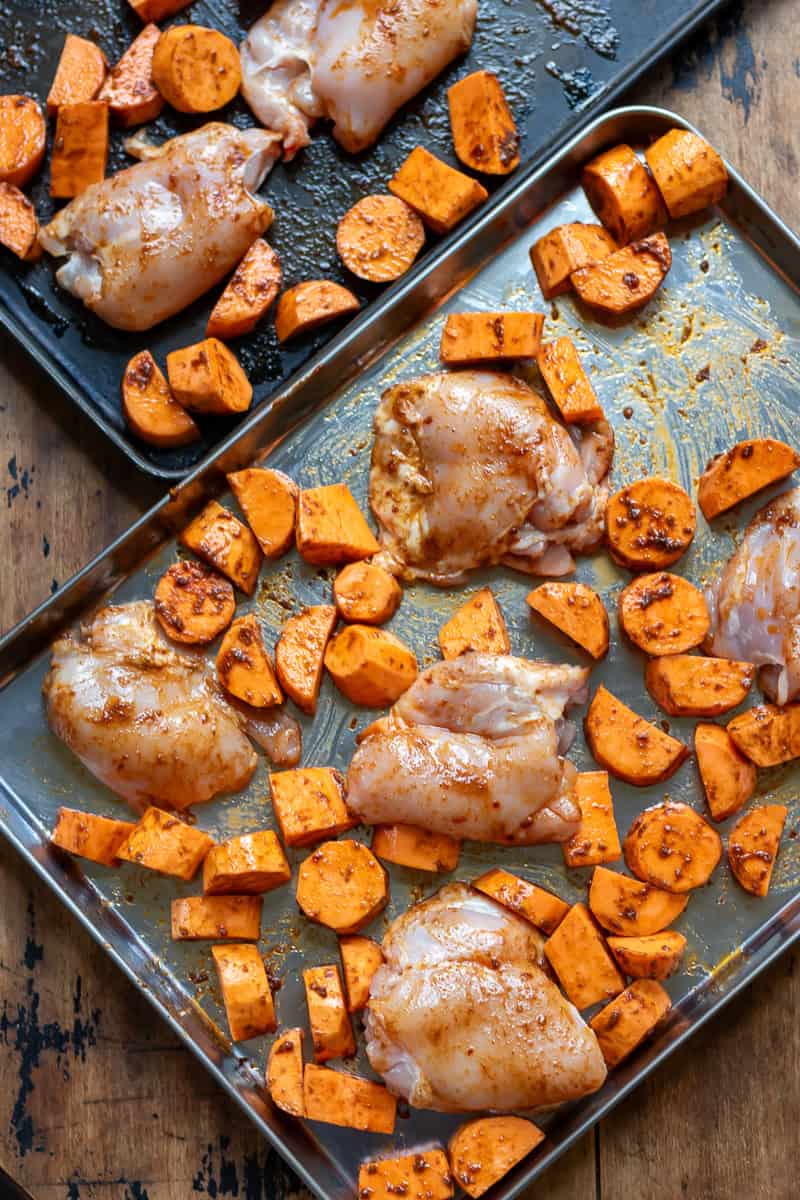 Chicken thighs on the baking sheets.