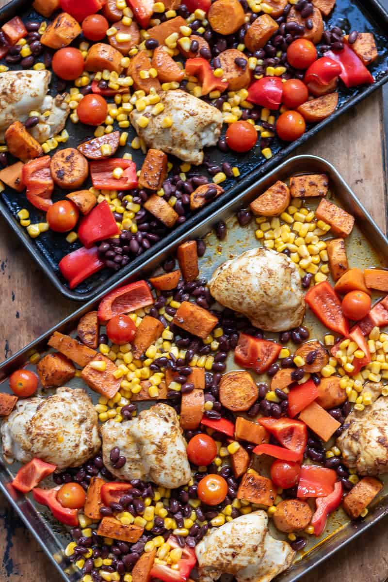 Tomatoes, bell peppers, black beans and corn added to the sheet pans.
