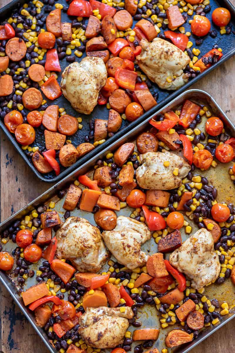 Two sheet pans of chipotle chicken with sweet potatoes and beans.