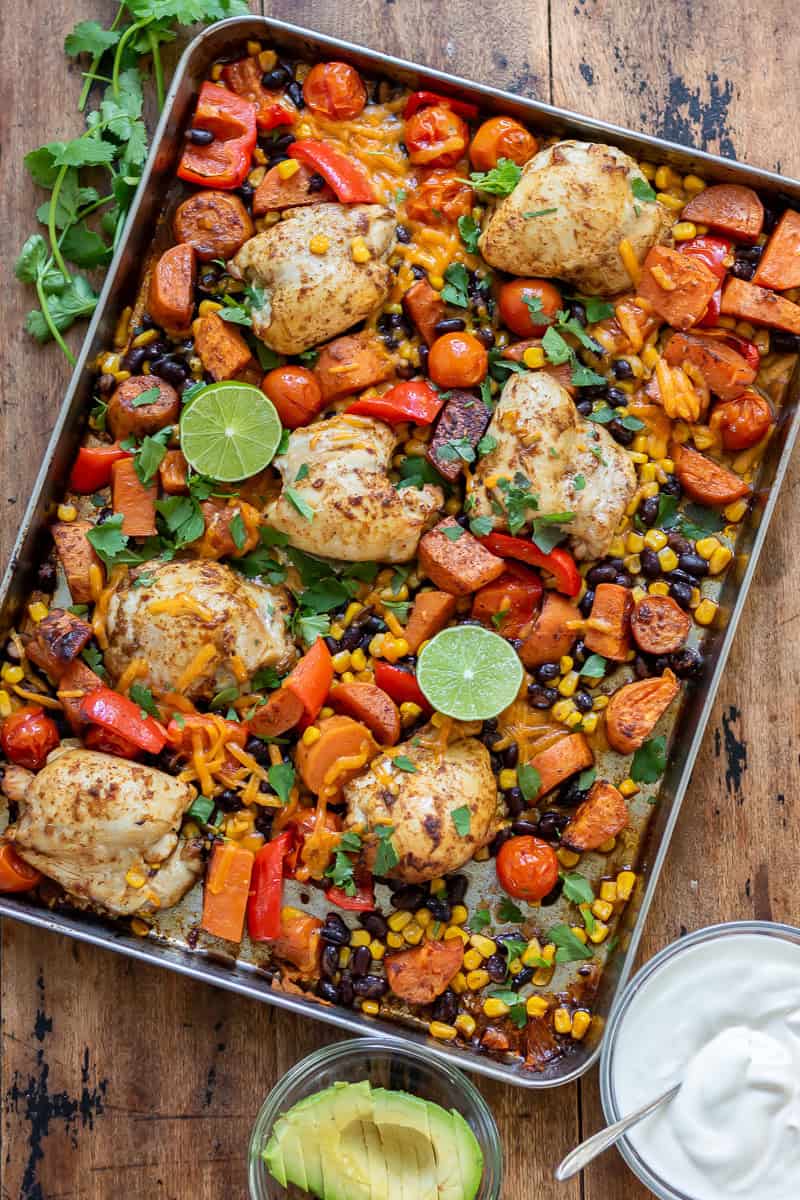 Looking down at a table with a pan of Chipotle Chicken Sweet Potato Sheet Pan Dinner.