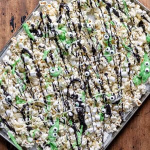 Tray of Halloween Monster Popcorn drizzled with coloured white chocolate and sprinkled with candy eyes and mini marshmallows.