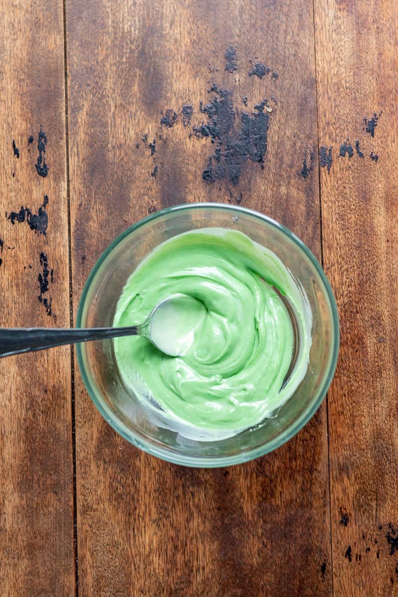 Green food colouring stirred into a dish of white chocolate.